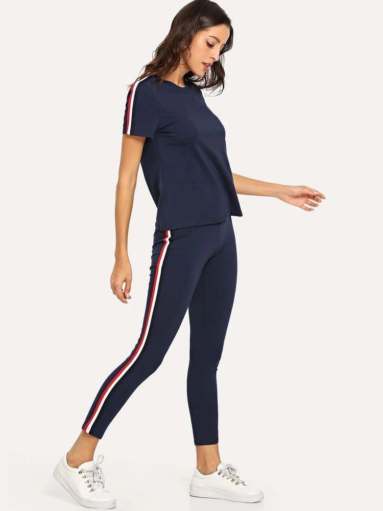 Tracksuit Set S (Category: Activewear) located in Makati City. Submitted by refind.prelove.finds (Listing ID 1467175231, Image 1). Description: - Navy blue t-shirt and leggings set - Features sporty red and white stripes on sleeves and down the sides of leggings - Comfortable and casual design - Ideal for lounging or light activity - Made from soft and stretchy fabric.