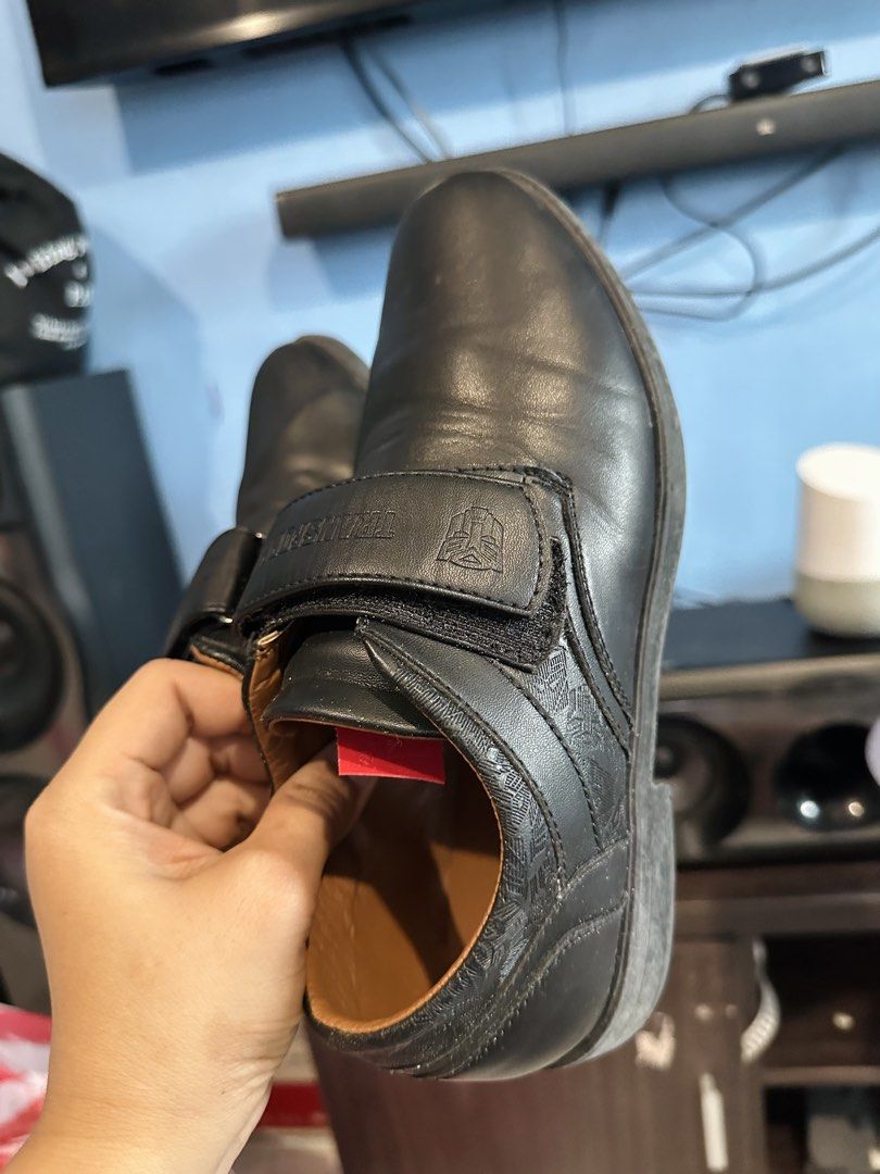 Transformers Black School Shoes Size 37 (Category: Babies & Kids Fashion) located in Manila. Submitted by htaviles (Listing ID 1467347328, Image 3). Description: Transformers black leather school shoes in size 37. Features Velcro strap closure with embossed Autobot logo and Transformers branding on the strap and insole. Brown interior lining. Includes original Transformers shoe box with matching product stickers..