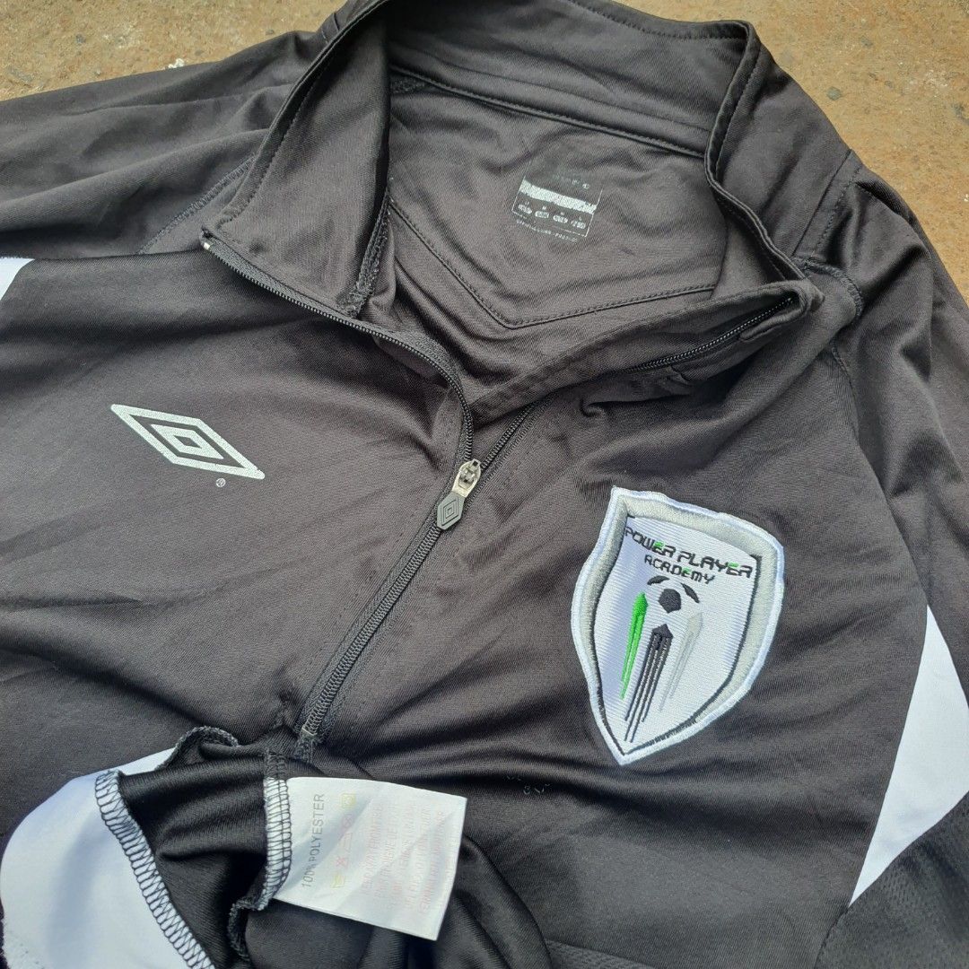 Umbro Q-Zip 2 Tone Long Sleeve Training Drill (Category: Activewear) located in Cavite. Submitted by josephnl (Listing ID 1467350344, Image 2). Description: - Brand: Umbro - Style: Long sleeve quarter-zip training drill top - Color: Black with white contrast panels - Logos: Embroidered Umbro diamond logo and Power Player Academy crest - Material: 100% polyester - Condition: Like new with tags attached - Size: Large (approx. 20" width x 27" length