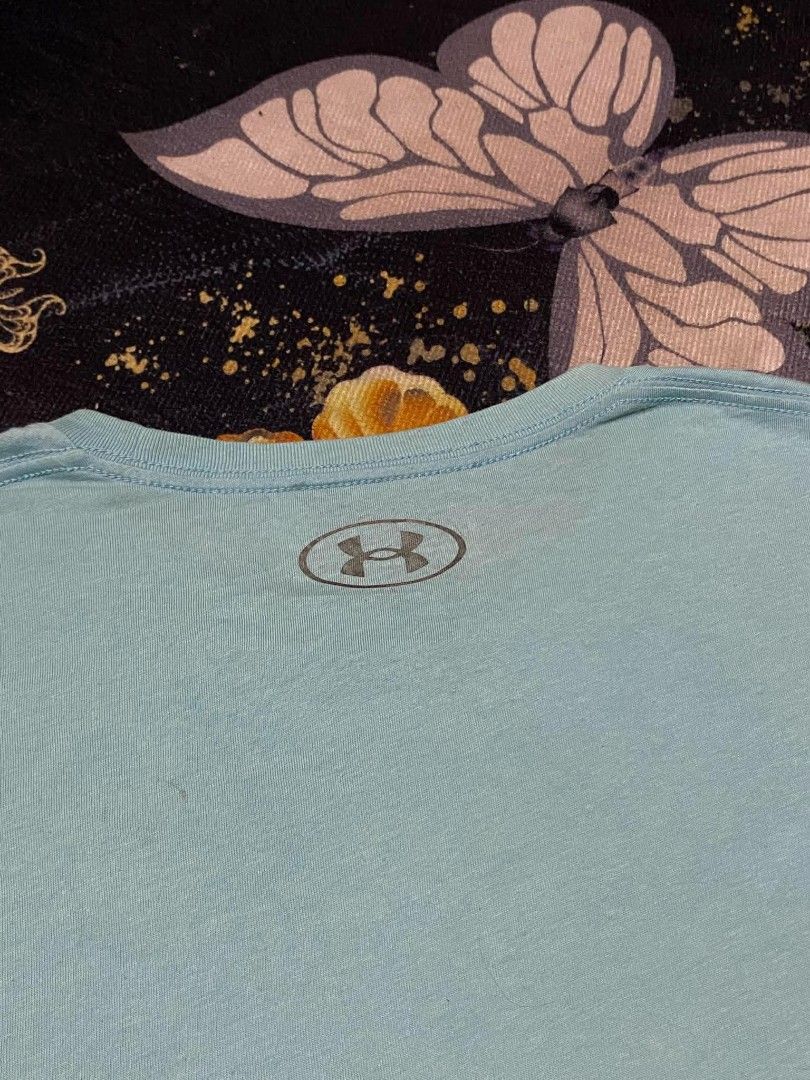 Under Armour Light Blue T-Shirt Medium (Category: Tshirts & Polo Shirts ) located in Manila. Submitted by thrift_sta.20 (Listing ID 1467206285, Image 3). Description: - Brand: Under Armour - Size: Medium - Color: Light Blue - Material: 60% cotton, 40% polyester (soft jersey fabric) - Details: Small logo on chest, larger oval logo on back collar - Origin: Made in Vietnam - Condition: Clean and excellent overall - Ideal for: Workouts or casual dail