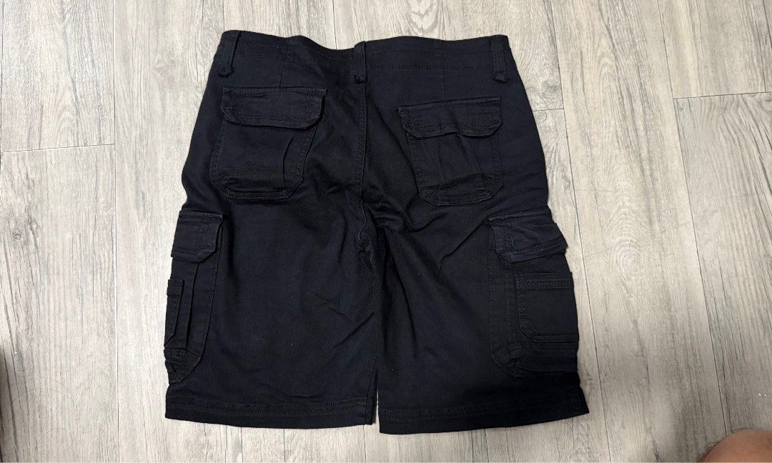 Unionbay Black Cargo Shorts Multiple Pockets (Category: Shorts) located in Caloocan City. Submitted by kobeeeee_12 (Listing ID 1467231709, Image 2). Description: - Brand: Unionbay - Color: Solid black - Material: Heavy-duty, durable cotton fabric - Storage: Multiple functional cargo pockets on sides and back - Design details: Contrast beige inner waistband with red branding print - Closure: Zip fly with button closure and belt loops - Condition/U