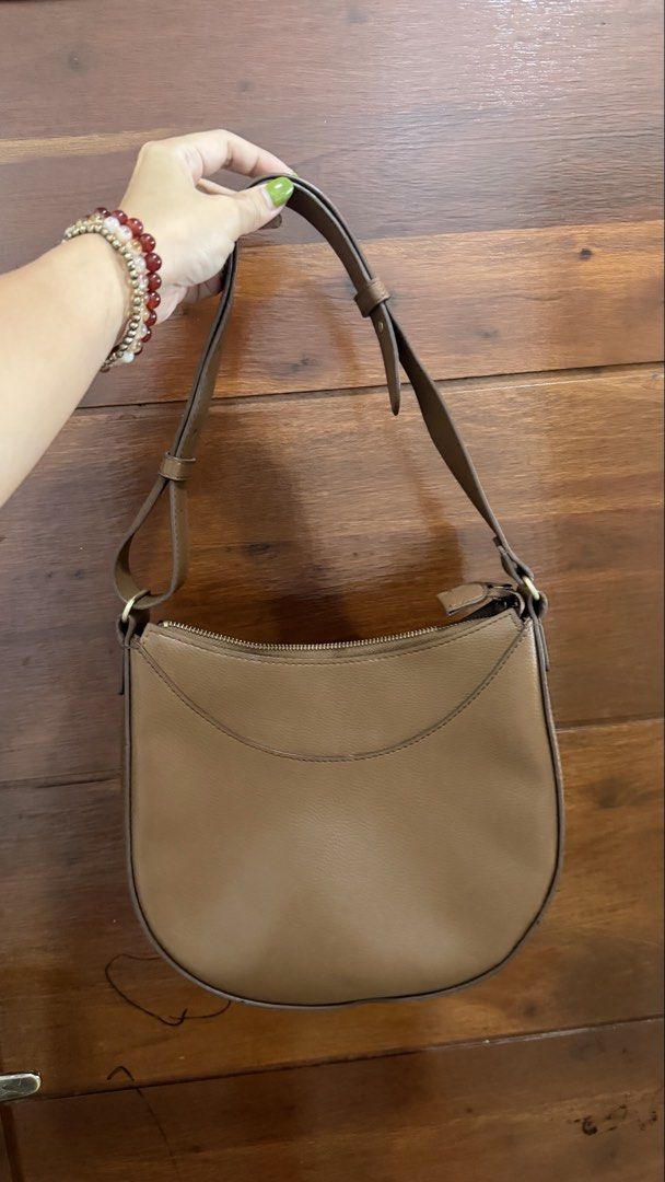 Uniqlo Brown Leather Shoulder Bag (Category: Shoulder Bags) located in Limay. Submitted by nimfalorraine (Listing ID 1467196914, Image 1). Description: - Style: Structured crescent shoulder bag - Material: Brown faux leather with clean interior lining - Hardware: Gold tone zipper closure and adjustable buckle strap - Condition: Minimal wear on the surface, well-maintained - Versatility: Classic neutral tone that matches any outfit.