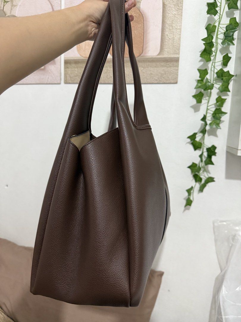 Urban Muse Shej Maxi Bag Brown (Category: Tote Bags) located in Manila. Submitted by ririjeon (Listing ID 1467229577, Image 3). Description: Used once only - Brand: Urban Muse - Color & Material: Rich brown faux leather with a textured pebble finish - Interior: Cream lining with a convenient center zippered compartment and two open sections - Straps: Comfortable dual shoulder straps - Details: Subtle gold metallic logo lettering on the front - In