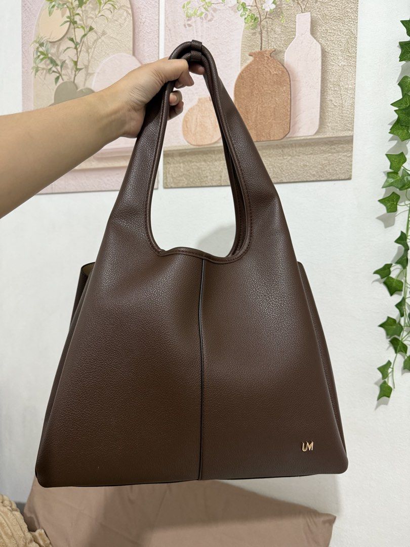 Urban Muse Shej Maxi Bag Brown (Category: Tote Bags) located in Manila. Submitted by ririjeon (Listing ID 1467229577, Image 1). Description: Used once only - Brand: Urban Muse - Color & Material: Rich brown faux leather with a textured pebble finish - Interior: Cream lining with a convenient center zippered compartment and two open sections - Straps: Comfortable dual shoulder straps - Details: Subtle gold metallic logo lettering on the front - In