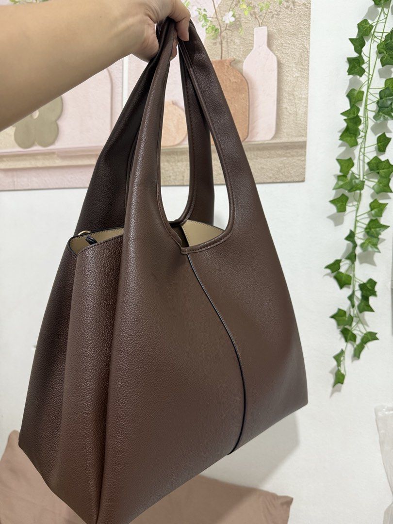 Urban Muse Shej Maxi Bag Brown (Category: Tote Bags) located in Manila. Submitted by ririjeon (Listing ID 1467229577, Image 2). Description: Used once only - Brand: Urban Muse - Color & Material: Rich brown faux leather with a textured pebble finish - Interior: Cream lining with a convenient center zippered compartment and two open sections - Straps: Comfortable dual shoulder straps - Details: Subtle gold metallic logo lettering on the front - In