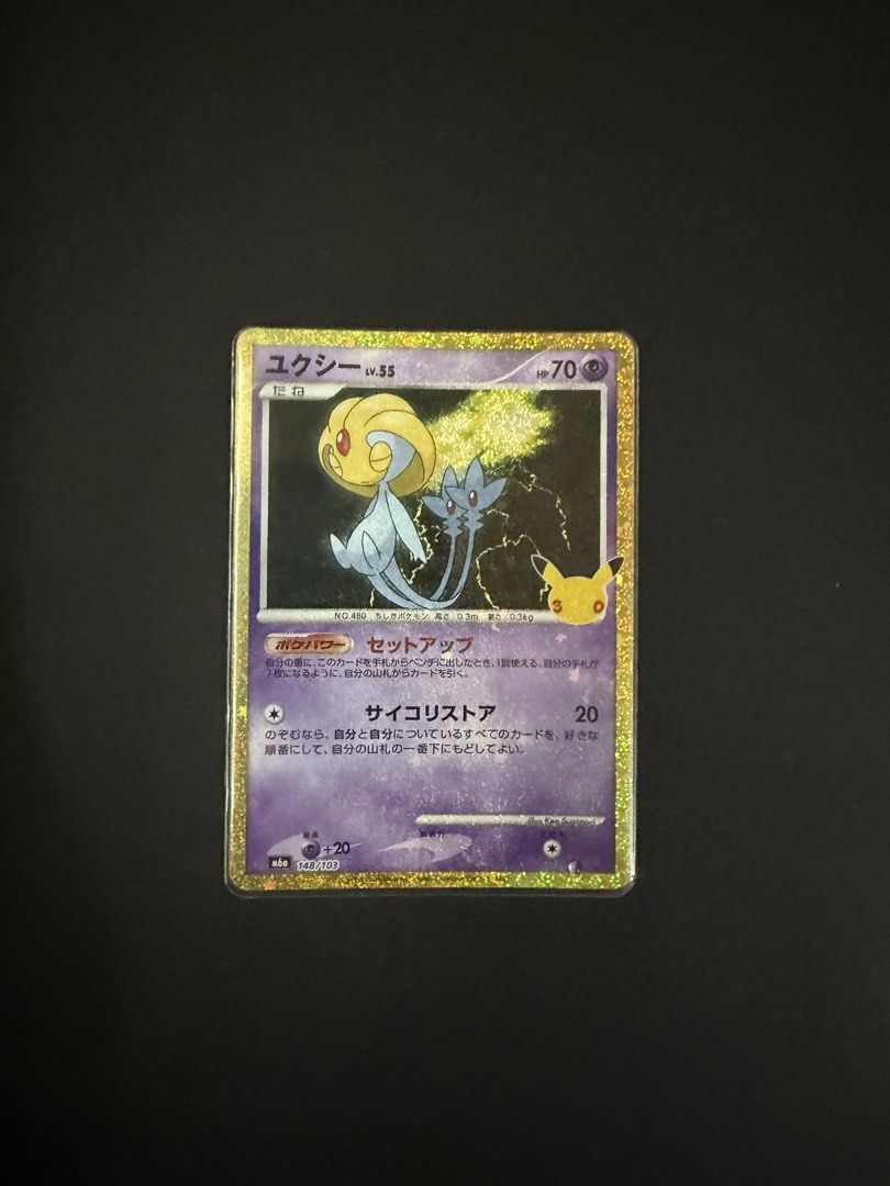 Uxie (Category: Raw Singles) located in Quezon City. Submitted by psybeam (Listing ID 1467303318, Image 1). Description: - Card: Uxie (Secret Rare) - Set: 25th Anniversary Celebrations (Japanese) - Card Number: 148/103 - Rarity/Finish: Holofoil Golden Border with Sparkle Finish - Stats: Psychic Type, 70 HP, Level 55 - Condition: Near Mint, stored in a protective sleeve - Ideal for collectors and binder displays - 100% authentic.