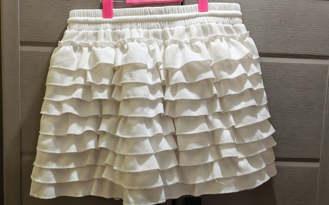 Valentino Paris White Ruffled Skort (Category: Skirts) located in Mandaluyong City. Submitted by trisha_001 (Listing ID 1467274201, Image 3). Description: - Brand: Valentino Paris - Color: White - Size: Tag says size 7 - Material: 100% cotton with viscose ribbed details - Design: Multiple tiered ruffles cascading down the front - Waist: Elastic waistband with adjustable drawstring closure - Condition: Clean and ready to wear - 28 to 32 inches wai