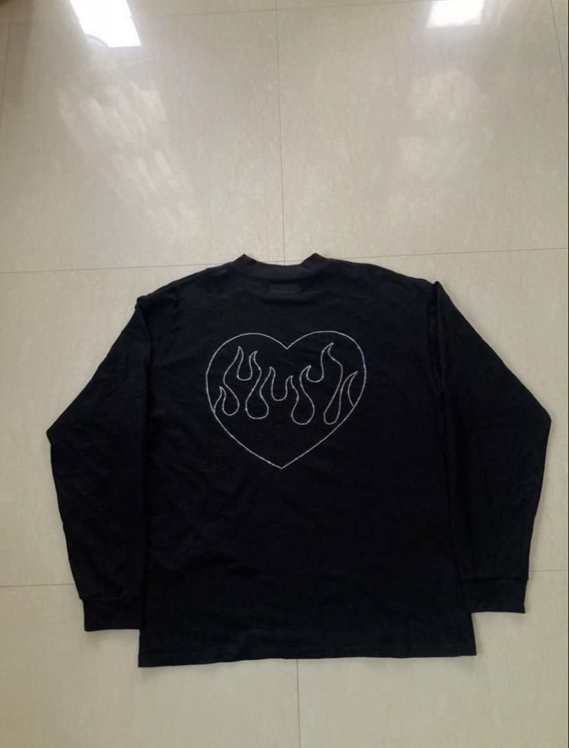 VETEMENTS LONG SLEEVES (Category: Tshirts & Polo Shirts ) located in Manila. Submitted by akirasaint_ (Listing ID 1467277138, Image 2). Description: - Vetements long sleeve shirt - Features rhinestone “VETEMENTS” logo - Heart and flame design on the back - Size: M - Collection: Autumn/Winter 2021 - Made in Portugal - Material: 100% cotton - Dimes: 22 x 28 - Issue: Missing Beads PHOTO FROM PREV OWNER.