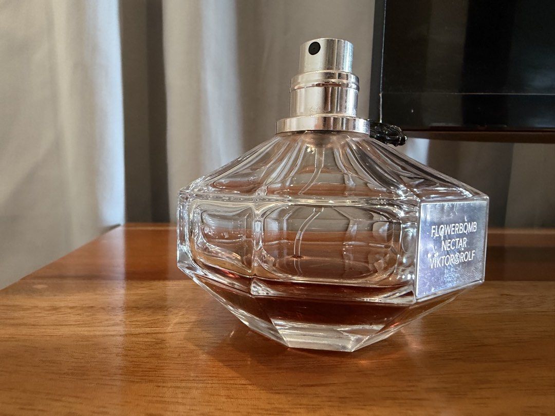 Viktor & Rolf Flowerbomb Nectar EDP 90ml (Category: Fragrance & Deodorants) located in San Antonio. Submitted by luvstuffffff (Listing ID 1467180102, Image 2). Description: Viktor and Rolf Flowerbomb Nectar Eau de Parfum. 90ml bottle size. Around a quarter of the fragrance remains inside. Batch code 22UD02L printed on the bottom. Heavy glass grenade-shaped bottle with metal seal tag attached to the neck. Spray nozzle works fine. Authentic bottle 