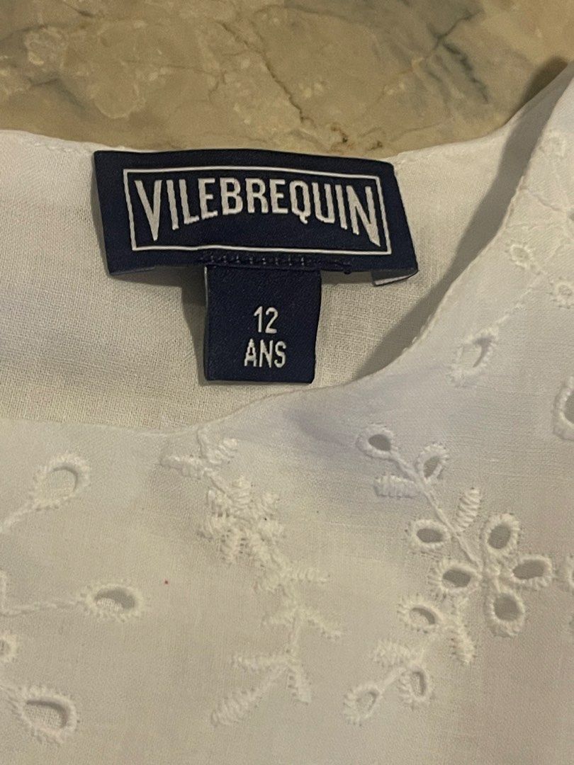 Vilebrequin White Eyelet Dress (Category: Babies & Kids Fashion) located in San Juan City. Submitted by rike_ramirez (Listing ID 1467206055, Image 3). Description: - Brand: Vilebrequin - Size: 12 years old - Material: 100% lightweight cotton - Design: Sleeveless with intricate floral embroidery, dropped waist, and gathered skirt - Details: Scalloped trim and back button closure at the neckline - Condition: Excellent.