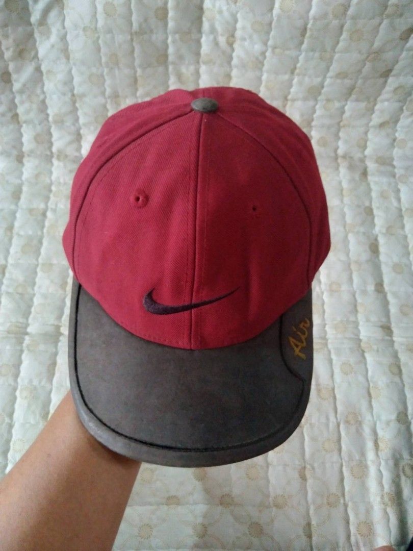 Vintage 90's Nike Air Red Cap (Category: Caps & Hats) located in Zamboanga. Submitted by nurbya898048 (Listing ID 1467260514, Image 2). Description: This is a vintage 1990s Nike Air cap 6 panel. Bown leather brim featuring embroidered Air text on the side. Black swoosh embroidered on the front panels. Adjustable leather strap at the back with metal buckle. Classic unstructured dad hat shape. .