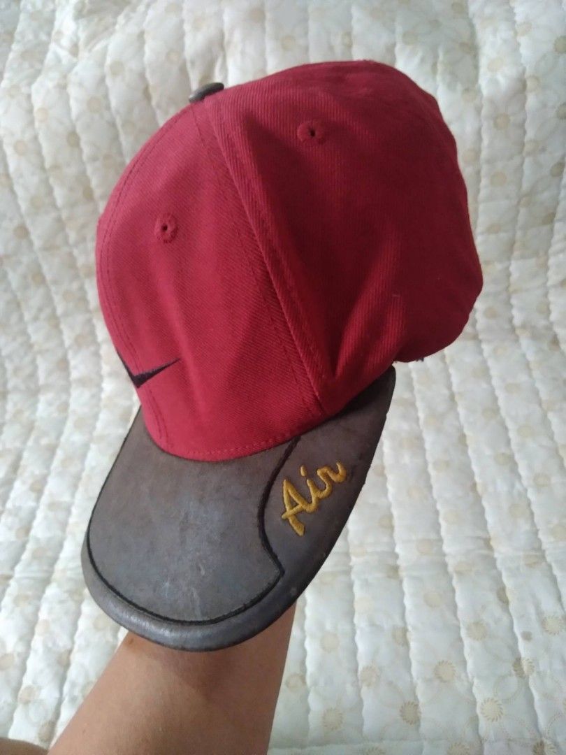 Vintage 90's Nike Air Red Cap (Category: Caps & Hats) located in Zamboanga. Submitted by nurbya898048 (Listing ID 1467260514, Image 3). Description: This is a vintage 1990s Nike Air cap 6 panel. Bown leather brim featuring embroidered Air text on the side. Black swoosh embroidered on the front panels. Adjustable leather strap at the back with metal buckle. Classic unstructured dad hat shape. .