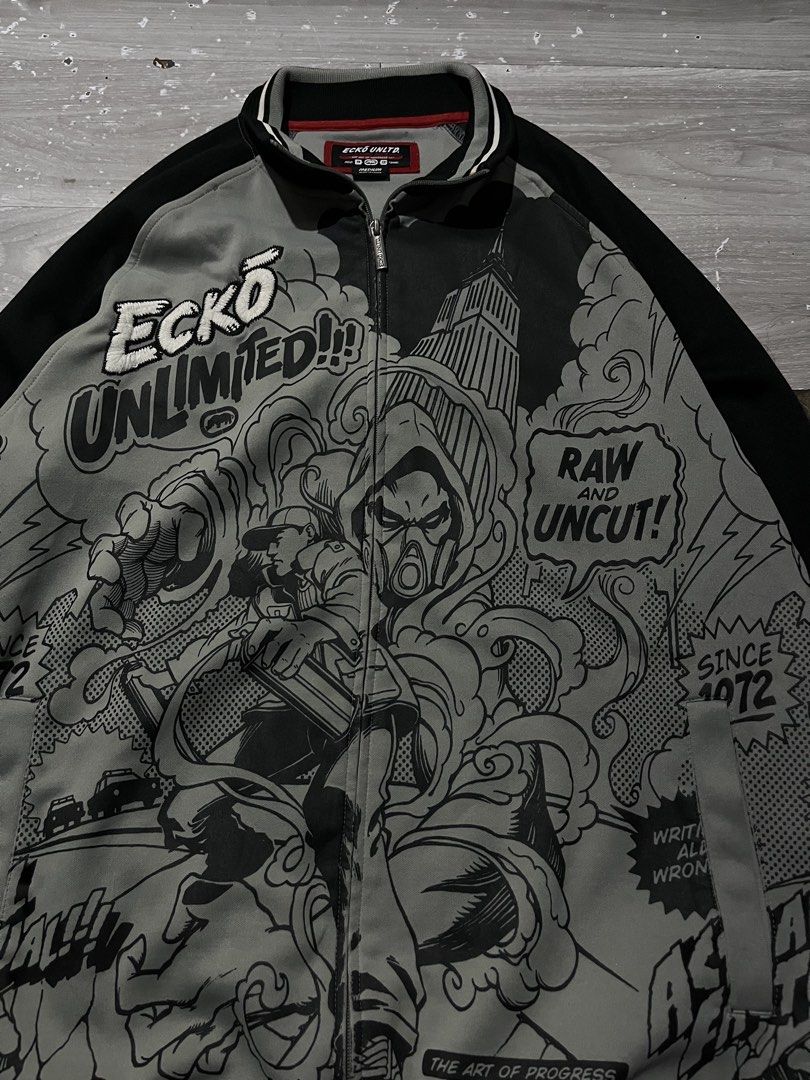 VINTAGE ECKO TRACK JACKET (Category: Coats, Jackets and Outerwear) located in Manila. Submitted by randomloots2 (Listing ID 1467291085, Image 2). Description: - Brand: Marc Ecko - Size: Medium - Color: Black, grey, and white - Design: Bold comic book graphic print with 'Ecko Unlimited!!!' embroidery - Details: Full front zipper with branded metal pull, striped ribbed collar, cuffs, and hem - Condition: Inner neck label and care instructions attac