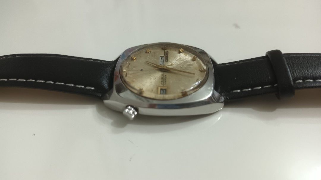 Vintage Seiko wath (Category: Men's Watches) located in Manila. Submitted by elytoot_1891 (Listing ID 1467250489, Image 3). Description: - Brand/Model: Vintage Seiko Automatic (Case: 6119-7100, Serial: 801205) - Movement: 21 Jewels automatic 6119 movement - Case & Strap: Silver-tone cushion case paired with a black leather strap with white stitching - Features: worling Day-date windows - Condition: Noticeable aging and patina on the dial face, ad