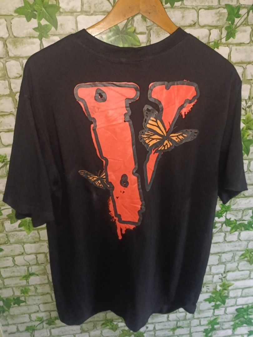 Vlone Juice WRLD Legends Never Die Tee Black (Category: Tshirts & Polo Shirts ) located in Carcar. Submitted by rolandobac92675 (Listing ID 1467357946, Image 2). Description: Vlone x Juice WRLD Legends Never Die t-shirt in black. Large red V logo on the back with orange butterflies. Small text print on the front chest reading legends never die with an orange V. Made in USA tag inside collar. Heavy cotton material..