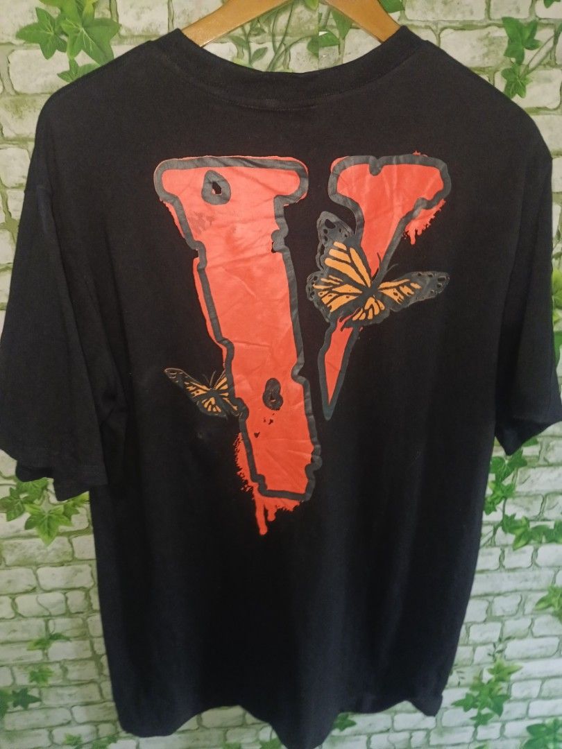 Vlone Juice WRLD Legends Never Die Tee Black (Category: Tshirts & Polo Shirts ) located in Carcar. Submitted by rolandobac92675 (Listing ID 1467357946, Image 1). Description: Vlone x Juice WRLD Legends Never Die t-shirt in black. Large red V logo on the back with orange butterflies. Small text print on the front chest reading legends never die with an orange V. Made in USA tag inside collar. Heavy cotton material..