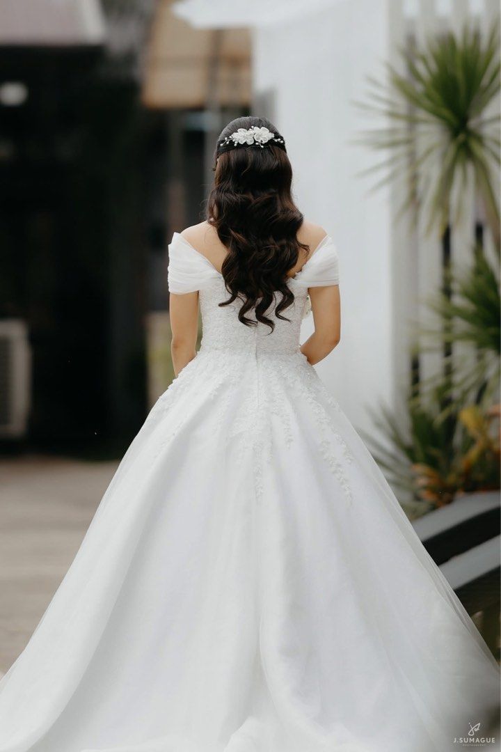 Wedding Gown with Detachable Sleeves (Category: Evening dresses & gowns) located in Tanauan. Submitted by au.annm (Listing ID 1467180460, Image 2). Description: - Neckline & Sleeves: Sweetheart neckline with draped off-shoulder sleeves - With detachable off-shoulder sleeves - Closure: Back zipper - Condition: Worn once during wedding, July 2026 - Freebies: Long and short veil, 2 pillows, petticoat Measurements: - Bust: 32in - Waist: 25.5in - Hips