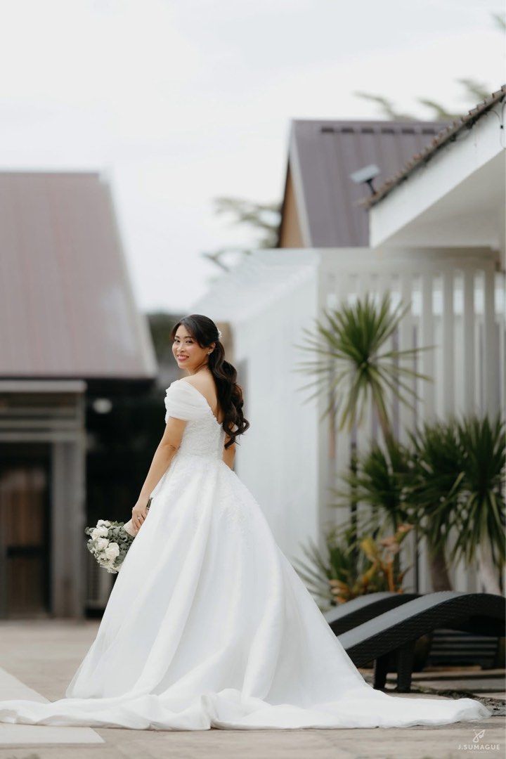 Wedding Gown with Detachable Sleeves (Category: Evening dresses & gowns) located in Tanauan. Submitted by au.annm (Listing ID 1467180460, Image 1). Description: - Neckline & Sleeves: Sweetheart neckline with draped off-shoulder sleeves - With detachable off-shoulder sleeves - Closure: Back zipper - Condition: Worn once during wedding, July 2026 - Freebies: Long and short veil, 2 pillows, petticoat Measurements: - Bust: 32in - Waist: 25.5in - Hips