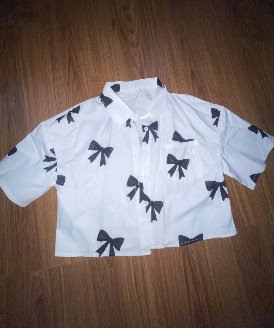 White Button-Up Shirt With Black Bow Print (Category: Shirts) located in Marikina City. Submitted by owloui (Listing ID 1467341721, Image 1). Description: rfs: decluttering ‼️NO COD Color & Pattern: White with all-over black bow print (front and back) Fit: Boxy Condition: BRAND NEW (never been worn) Free size, will fit S-M.