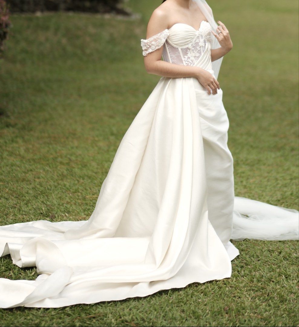 White Corset Style Wedding Dress with Train (Category: Evening dresses & gowns) located in Makati City. Submitted by movingpeach (Listing ID 1467229397, Image 3). Description: - Color: White - Design: Structured corset bodice with sheer lace panelling and a sweetheart neckline, can be worn with straps up or down - Straps: Delicate off-the-shoulder lace straps - Skirt: Smooth satin featuring a high side slit and a dramatic flowing train - Conditio