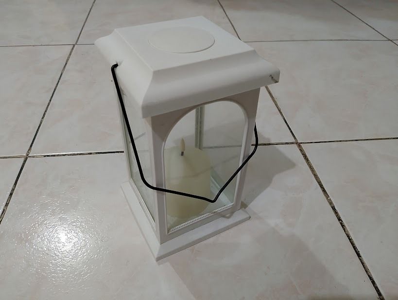 White Decorative Candle Lantern with Pillar Candle (Category: Lighting) located in Quezon City. Submitted by susmaryosep1 (Listing ID 1467268885, Image 2). Description: - Color: White with glass panels - Features: Built-in candle included - Handle: Black metal handle for hanging or carrying - Style: Clean modern design - Usage: Ideal for living room or patio decor 500 .