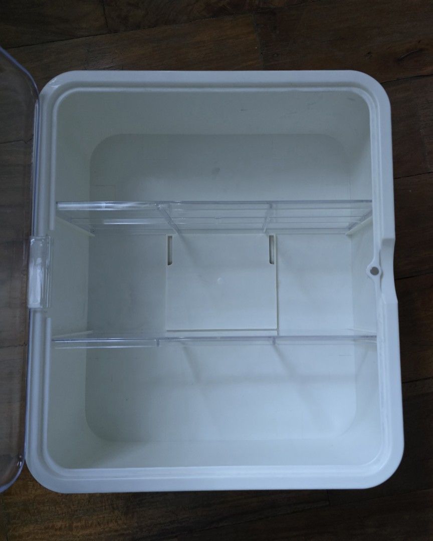 White Plastic Desktop Storage Organizer with Clear Door (Category: Storage Boxes & Baskets) located in Manila. Submitted by minihobbies23 (Listing ID 1467196669, Image 2). Description: - Color & Material: Solid white plastic with a transparent front door - Layout: 2 horizontal shelves creating 3 main sections. Removeable shelves. - Dimensions: Approx. 11 inches tall x 9.5 inches wide - Condition: Clean and ready to use - Best for: Organizing cosm