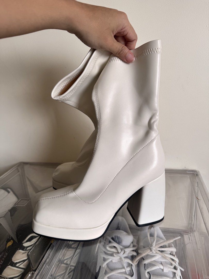 White platform block heel boots chunky boots (Category: Boots) located in Pasig City. Submitted by reneltibo33257 (Listing ID 1467187330, Image 2). Description: - Color: White -Size 37 - Style: Mid-calf chunky boots with a thick platform and block heel - Design: Trendy square toe with stretch material around the shaft for comfort - Soles: Sturdy and built to last - Condition: Pre-loved with minor scuff marks near the toe and heel area.