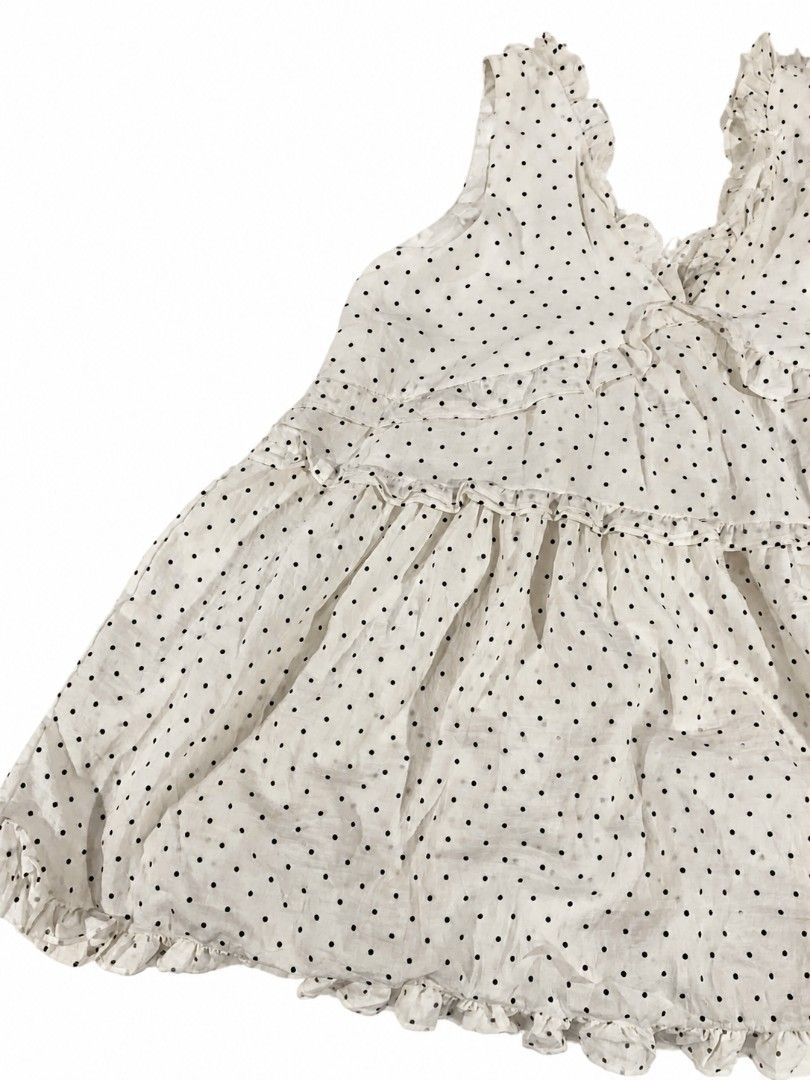 White Polka Dot Ruffle Sleeveless Blouse (Category: Sleeveless) located in Kananga. Submitted by aurylien.clo (Listing ID 1467194800, Image 3). Description: - medium to large - Color/Pattern: Classic white with black polka dots - Design: Sleeveless with ruffled V-neck and tiered front ruffles - Fit: Relaxed babydoll fit with a flared hem - Material: Lightweight, textured swiss dot fabric - Style Tip: Great for warm weather; easy to dress up or do