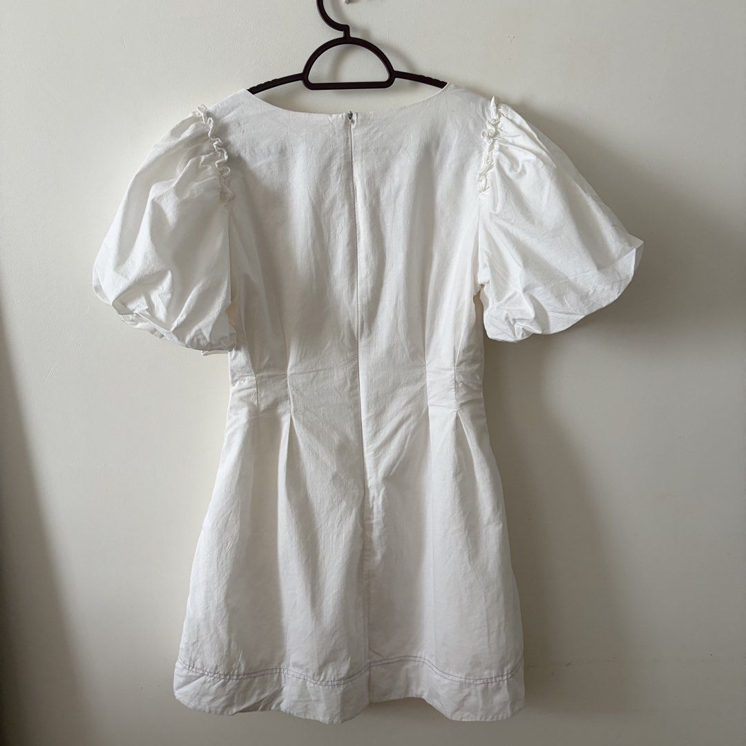 White puff sleeve v-neck mini dress (Category: Dresses) located in Mandaluyong City. Submitted by shaine.dc (Listing ID 1467207178, Image 3). Description: - Mini dress with short puff sleeves and v-neck. Front button design only. - Issue: broken zipper handle but zipper is functional - Best for small. Length above the knee for 5’3” height.