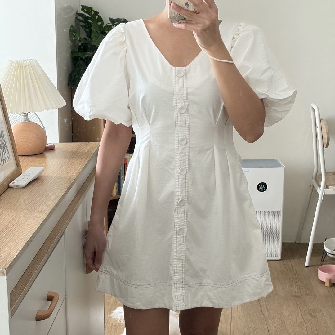 White puff sleeve v-neck mini dress (Category: Dresses) located in Mandaluyong City. Submitted by shaine.dc (Listing ID 1467207178, Image 1). Description: - Mini dress with short puff sleeves and v-neck. Front button design only. - Issue: broken zipper handle but zipper is functional - Best for small. Length above the knee for 5’3” height.