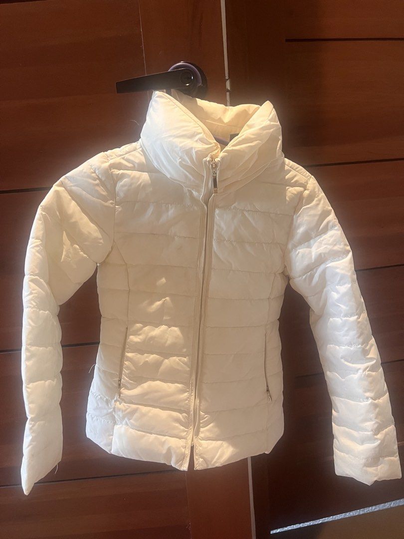 White Puffer Jacket Quilted Winter Coat (Category: Coats, Jackets and Outerwear) located in Manila. Submitted by asecondstory (Listing ID 1467336346, Image 1). Description: - Color: White - Style: Quilted puffer jacket with a fitted cut - Closure & Neckline: Zip-up front with a high collar for wind protection - Pockets: Two functional side pockets with zippers - Condition: Clean, excellent, and ready to wear - Perfect for keeping warm during cold