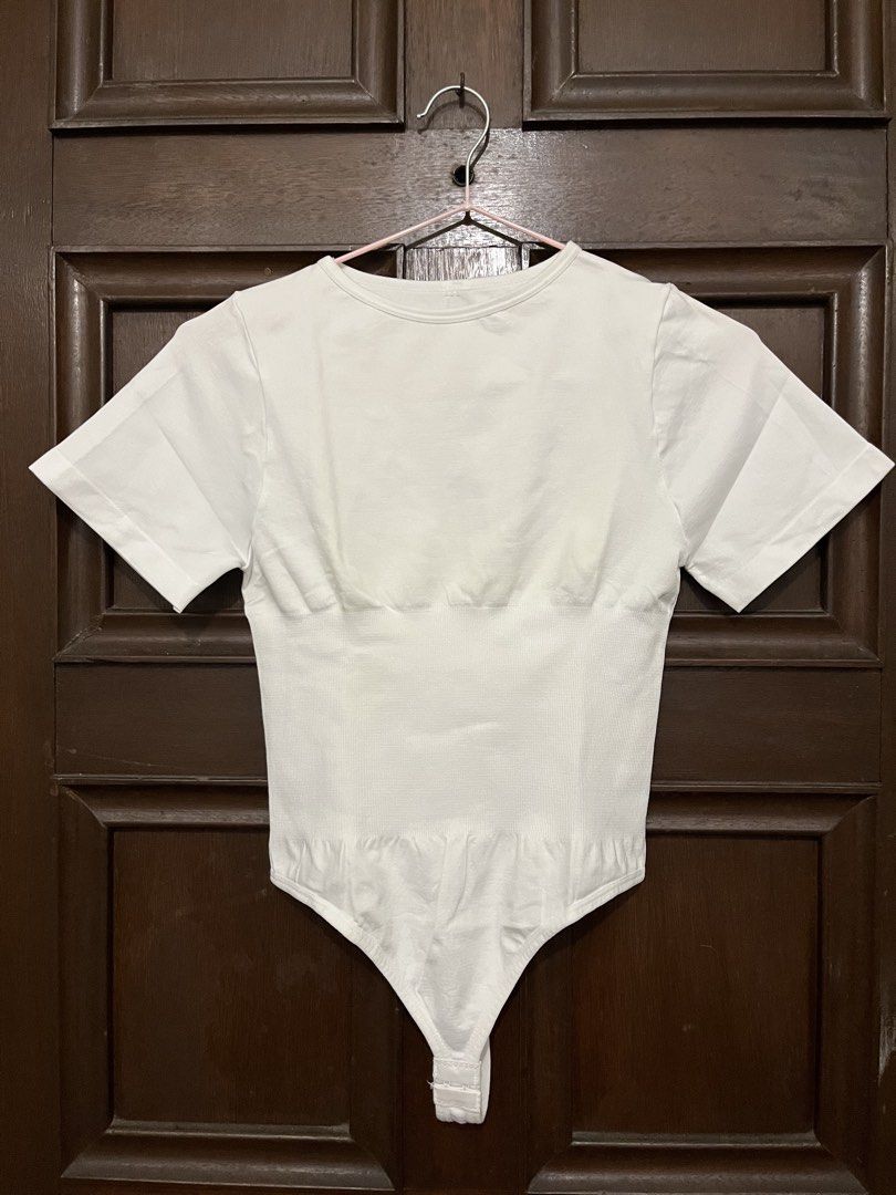 White Shapewear Bodysuit (Category: Shirts) located in Makati City. Submitted by yoursecondbest (Listing ID 1467255302, Image 1). Description: - Color: Clean solid white - Style: Short sleeve crew neck bodysuit - Design: Seamless with ribbed torso texture - Fit: Built-in shaping panels under the bust - Closure: Convenient snap buttons at the bottom - Versatility: Great basic piece for layering.