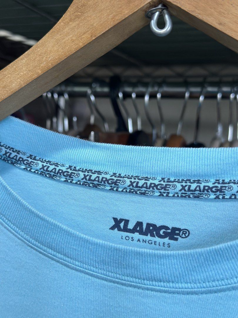 XLARGE Los Angeles Light Blue Tee Size L (Category: Tshirts & Polo Shirts ) located in Daet. Submitted by thrifthings2018 (Listing ID 1467246385, Image 3). Description: - Brand: XLARGE Los Angeles - Color: Light blue with pink chest logo graphic - Size: Large (Width: 22 inches, Length: 30 inches) - Material: 100% cotton - Condition: Clean fabric, tag attached, ready to wear.
