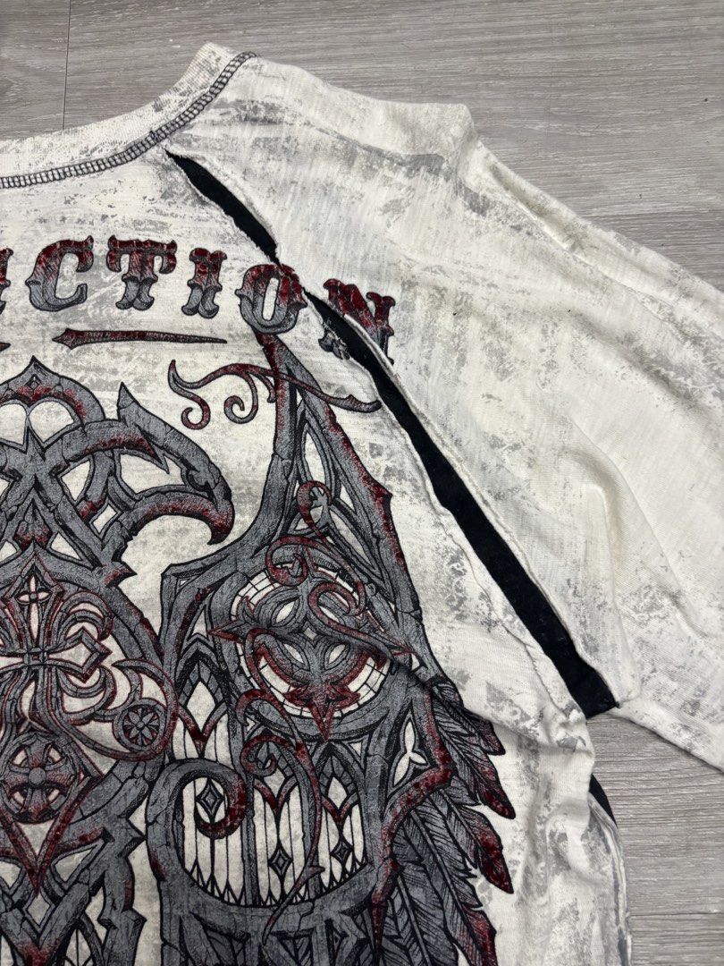 Y2K Affliction Sweater (Category: Tshirts & Polo Shirts ) located in Pagadian. Submitted by afterwearph (Listing ID 1467338274, Image 3). Description: - Brand: Affliction - Color: Grey and white with contrasting black side panels - Style: Long sleeve crew neck with raw edges / Heavy metal Y2K aesthetic - Graphics: Large 'Live Fast' and cross design on chest, massive detailed wing graphic on the back - Shipping: Ships via J&T Express or local PH c