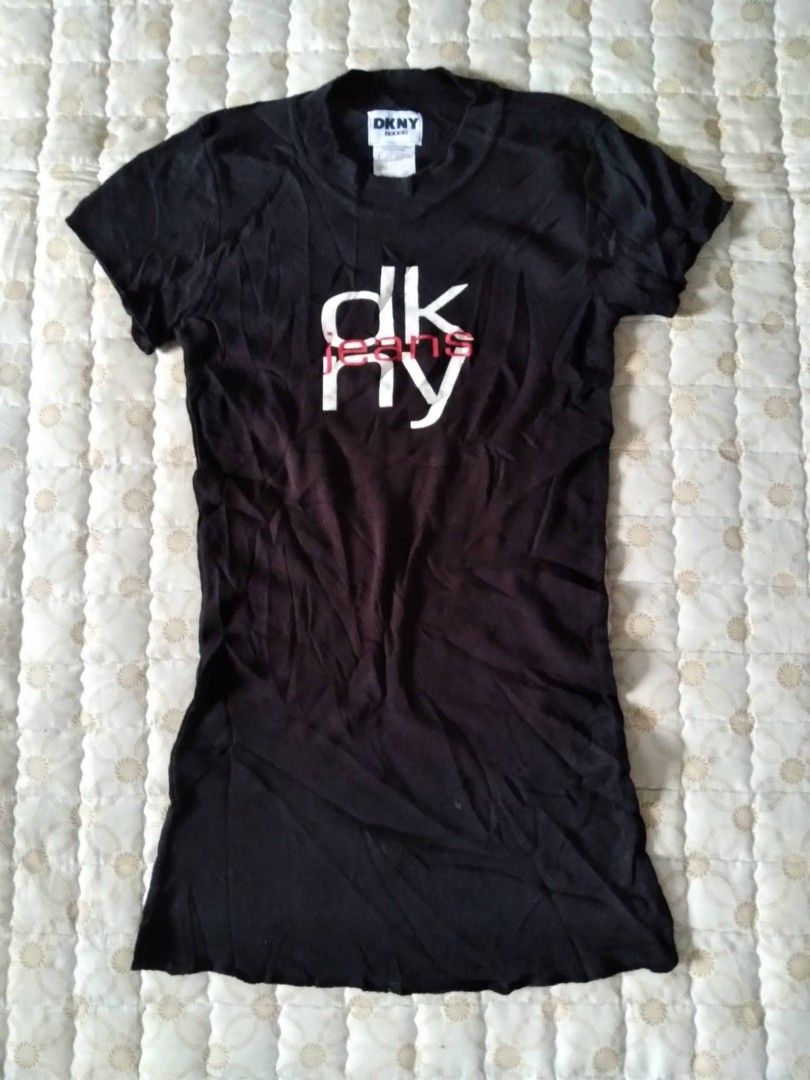 Y2k DKNY Black T-shirt Small (Category: Shirts) located in Zamboanga. Submitted by nurbya898048 (Listing ID 1467254222, Image 1). Description: Classic black DKNY Jeans short sleeve t-shirt. White and red graphic print on the front. Crew neck design, slim fit style. Tag says size P/S. Made in USA. 99 percent cotton, 1 percent other materials. Fabric feels soft and comfortable. Great Y2K aesthetic piece. Tag size small Excellent condition Presentab