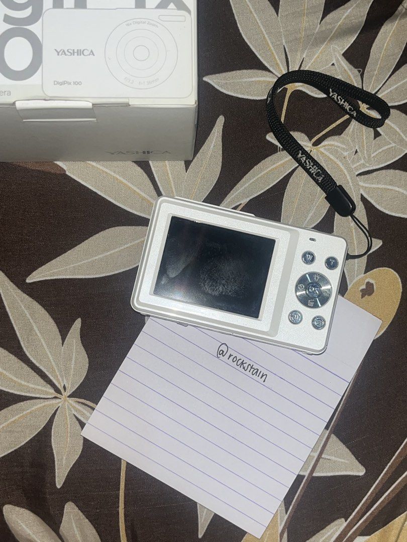 Yashica DigiPix 100 | READ DESCRIPTION (Category: Cameras) located in Mandaluyong City. Submitted by rockstain (Listing ID 1467253427, Image 3). Description: - Model: Yashica DigiPix 100 Compact Digital Camera (White) - Included: Original box and branded wrist strap (not included: charger) - Specs: f=7.36mm lens, F/3.2 aperture, up to 16x digital zoom - 10/10 Condition: Good working condition with minor fingerprint smudges on the rear screen, lig