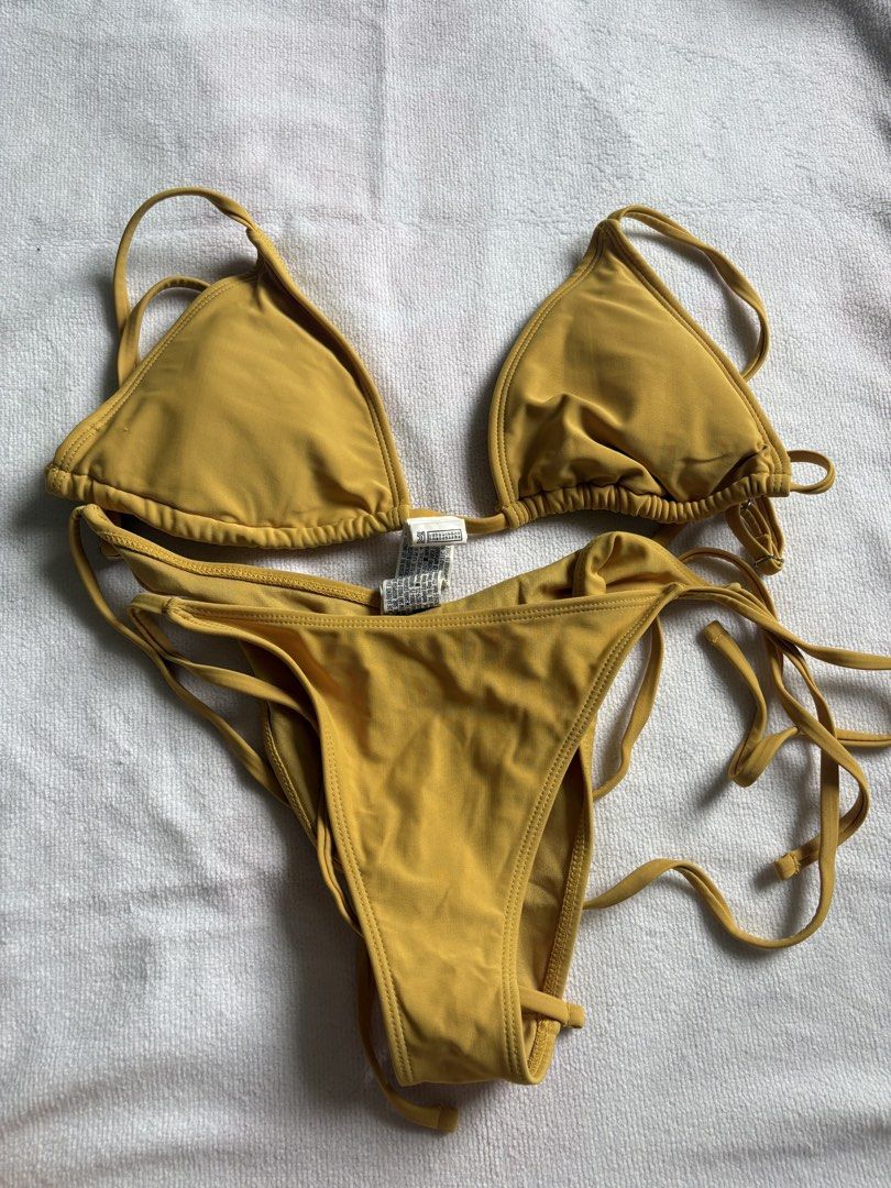 Yellow string bikini swimsuit two-piece set (Category: Bikinis & Swimsuits) located in Makati City. Submitted by katch2 (Listing ID 1467321271, Image 1). Description: - Color: Vibrant mustard yellow - Style: Two-piece bikini with triangle top and low-rise bottoms - Condition: Like new - Features: Adjustable thin straps and side ties for a customizable fit - Ideal for: Beach trips, pool parties, and vacations.