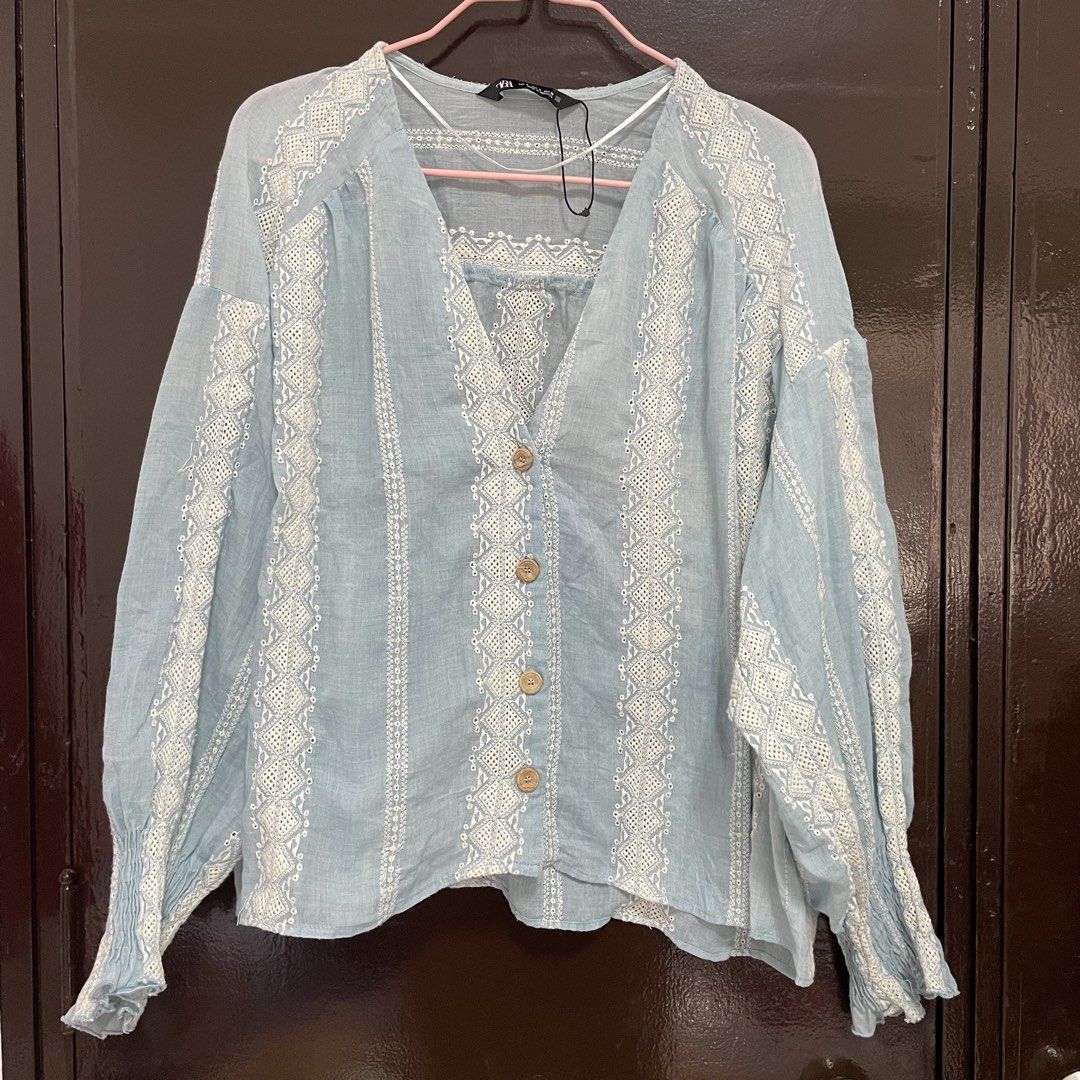 Zara Blue Embroidered Button-Down Blouse (Category: Blouses) located in Pasay City. Submitted by lovedbyzea (Listing ID 1467339747, Image 2). Description: - size S but can definitely fit up to Large - Brand: Zara - Color: Light blue with white intricate embroidery - Material: Comfortable linen-blend - Details: V-neckline, 4 brown wooden buttons, ruffled elastic cuffs - Fit: Loose and relaxed - Perfect for: Casual everyday wear, work-from-home, or