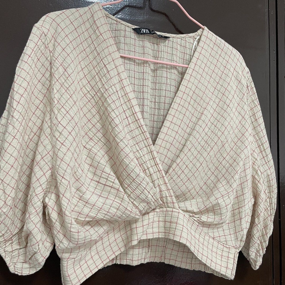 Zara Checkered Wrap Crop Blouse (Category: Blouses) located in Pasay City. Submitted by lovedbyzea (Listing ID 1467342212, Image 2). Description: - Brand: Zara - Size: S - Color/Pattern: Cream with pink and green check - Details: V-neckline with wrap front twist, short puffed sleeves with elastic cuffs, textured gauze fabric - Origin: Made in Morocco.
