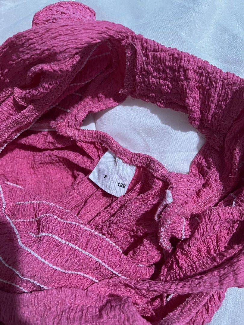 Zara Pink Crinkle Ruffle Jumpsuit Size 7 122 (Category: Babies & Kids Fashion) located in Catbalogan. Submitted by declutterfind (Listing ID 1467347488, Image 3). Description: - Brand: Zara - Color: Bright Pink - Size: 7 (Height 122cm) - Material: Lightweight crinkle fabric - Features: Ruffled straps, open back, smocked elastic stitching - Fit: Wide leg, easy pull-on style.
