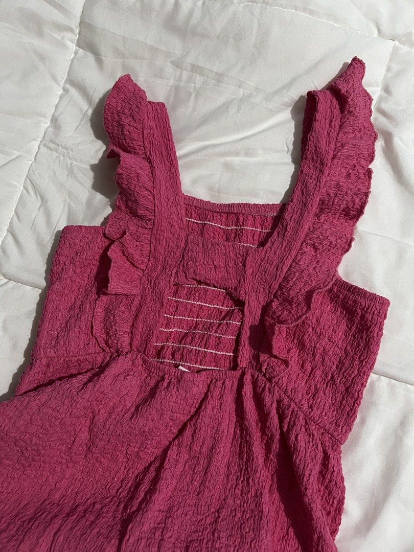 Zara Pink Crinkle Ruffle Jumpsuit Size 7 122 (Category: Babies & Kids Fashion) located in Catbalogan. Submitted by declutterfind (Listing ID 1467347488, Image 2). Description: - Brand: Zara - Color: Bright Pink - Size: 7 (Height 122cm) - Material: Lightweight crinkle fabric - Features: Ruffled straps, open back, smocked elastic stitching - Fit: Wide leg, easy pull-on style.