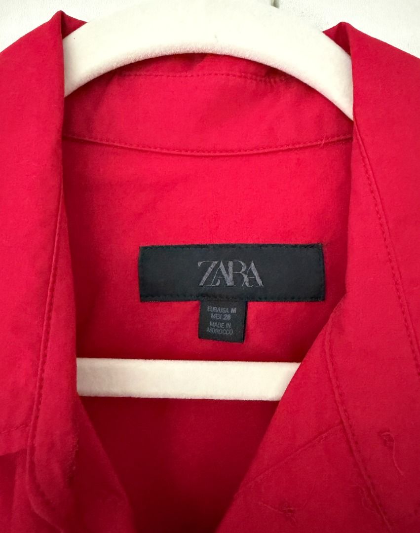 Zara Red Button Up Shirt (Category: Shirts) located in Caloocan City. Submitted by belizalde4 (Listing ID 1467212208, Image 3). Description: - Brand: Zara - Size: M - Color: Bright red - Origin: Made in Morocco - Details: Collared neckline, long sleeves, button cuffs - Condition: Clean, solid color design - Style: Versatile, easy to dress up or down.