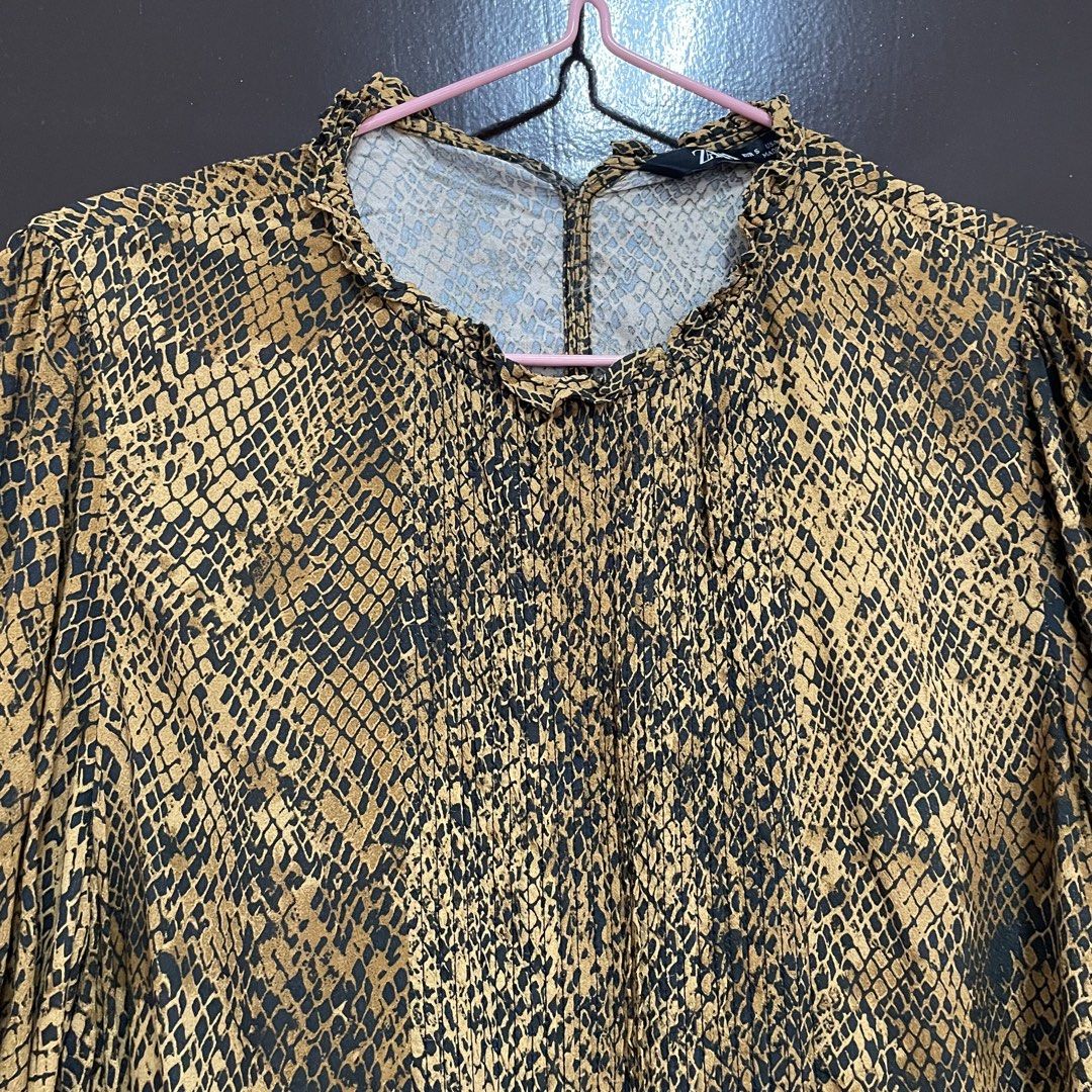 Zara Snake Print Long Sleeve Blouse (Category: Longsleeves) located in Pasay City. Submitted by lovedbyzea (Listing ID 1467340029, Image 3). Description: - the opening at the back was stitched closed. - Brand: Zara - Size: Small (tag attached) - Color/Pattern: Brown and black snake print - Details: Ruffle mock neck, long sleeves with smocked cuffs, elasticized hem - Material: Lightweight, comfortable fabric - Styling: Perfect for both casual deni
