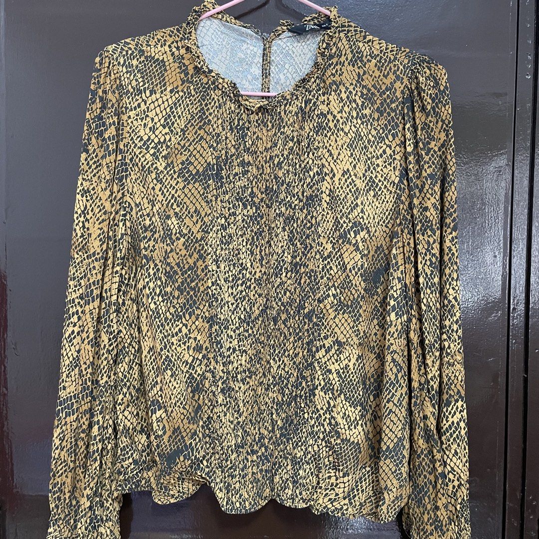 Zara Snake Print Long Sleeve Blouse (Category: Longsleeves) located in Pasay City. Submitted by lovedbyzea (Listing ID 1467340029, Image 2). Description: - the opening at the back was stitched closed. - Brand: Zara - Size: Small (tag attached) - Color/Pattern: Brown and black snake print - Details: Ruffle mock neck, long sleeves with smocked cuffs, elasticized hem - Material: Lightweight, comfortable fabric - Styling: Perfect for both casual deni