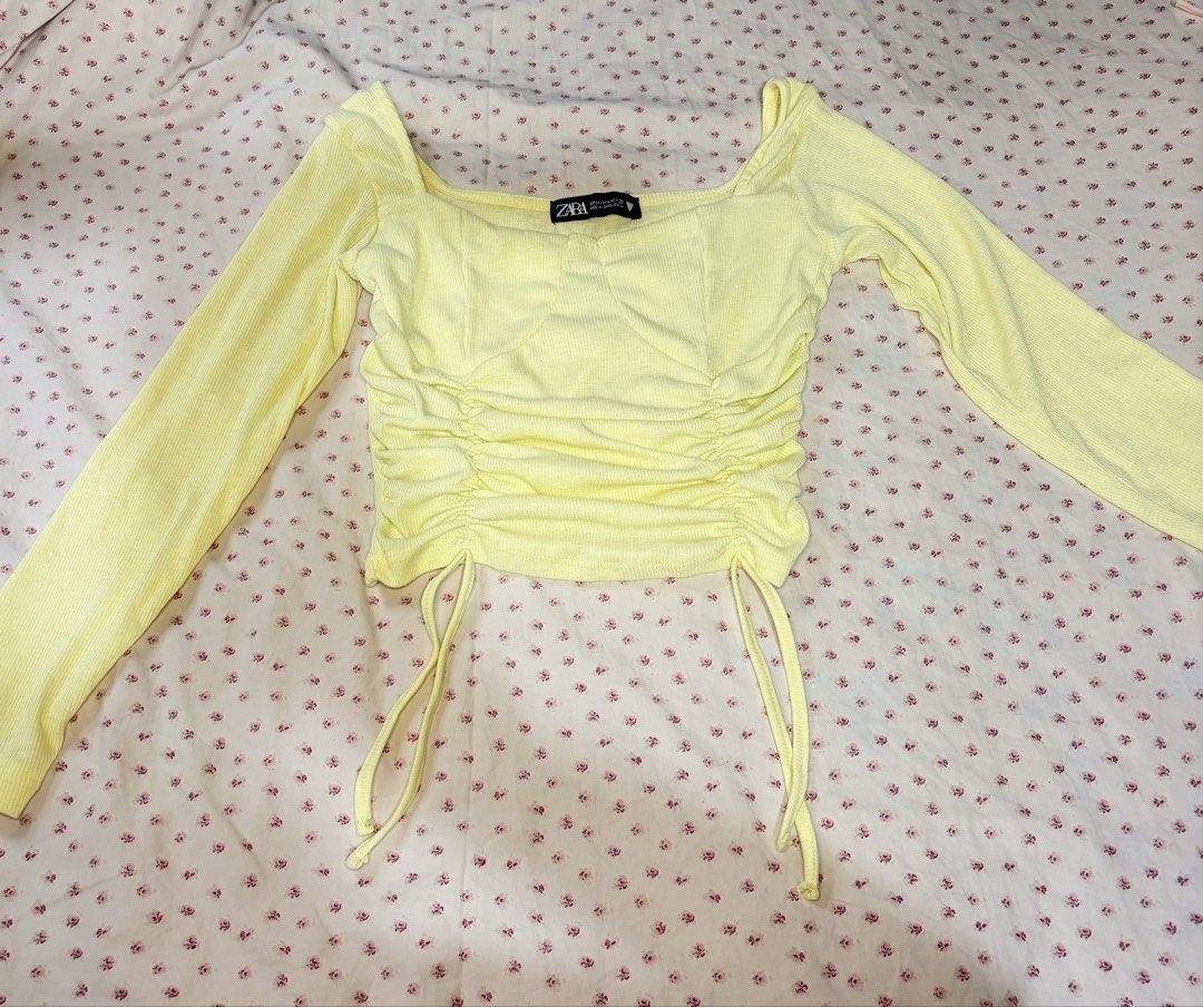 Zara Yellow Long Sleeve Ruched Top (Category: Longsleeves) located in Taguig. Submitted by riri_aofe (Listing ID 1467239071, Image 1). Description: - Color: Bright yellow/Pastel Yellow - Material: Ribbed texture - Design: Square neckline, structured bodice seams, and adjustable front drawstring ruching - Fit: Cropped length, long sleeves - Style: Casual and versatile, easy to dress up or down Negotiable‼️.