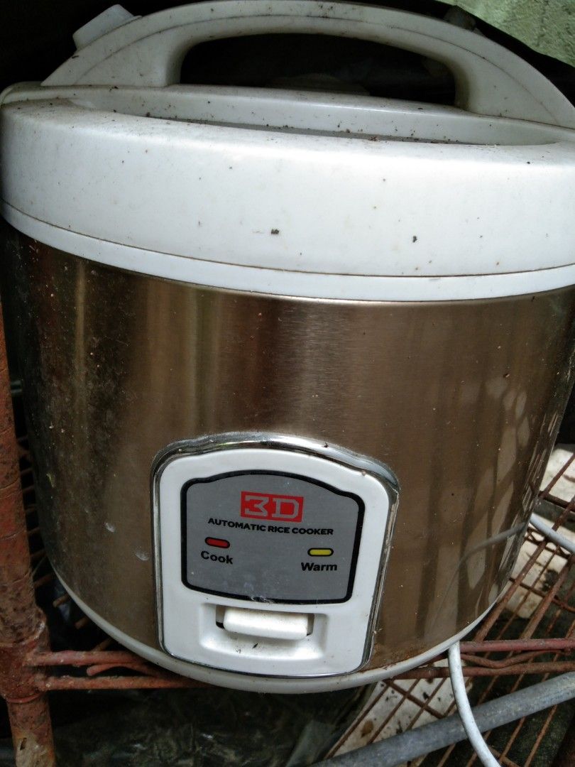 3D Automatic Rice Cooker (Category: Cookers) located in Quezon City. Submitted by eidorableshop (Listing ID 1467365094, Image 1). Description: - Color: Gold and White - Type: Automatic Rice Cooker - Features: Cook and warm indicator lights, lever switch - Plug: Standard two-prong plug - Condition: Shows storage dirt and grime; needs a good cleaning before use.