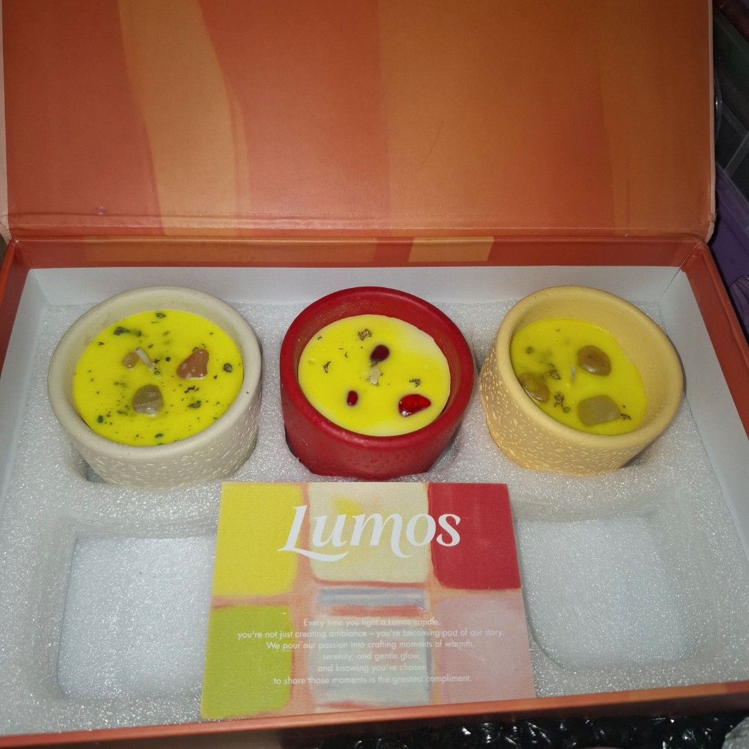 3pcs Aromatherapy Scented Candle Set (Category: Home Fragrance) located in Quezon City. Submitted by an.marie (Listing ID 1467418382, Image 1). Description: - Brand: Lumos - Product: Aromatherapy Scented Candle Gift Set - Inclusion: 3 colorful textured pots with yellow soy wax and embedded stones - Material: Soy wax blend infused with essential oils - Packaging: Comes in an elegant orange gift box with a branding card - Condition: Brand new, unus
