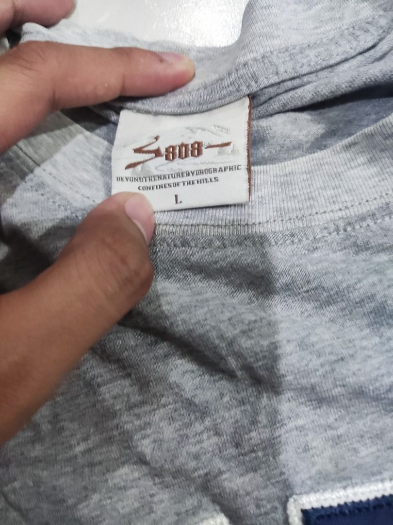 808 Grey Graphic T-Shirt Size L (Category: Tshirts & Polo Shirts ) located in Rizal. Submitted by skilidilidu (Listing ID 1467548420, Image 2). Description: - Brand: 808 - Style: Grey short-sleeve tee with collegiate lettering - Design: Bold 'NVTUV' print in dark blue with white outlining across the chest - Size: L (Tag included) - Details: Ribbed crew neck collar and brand label on the lower side seam - Versatility: Perfect for casual wear, easy