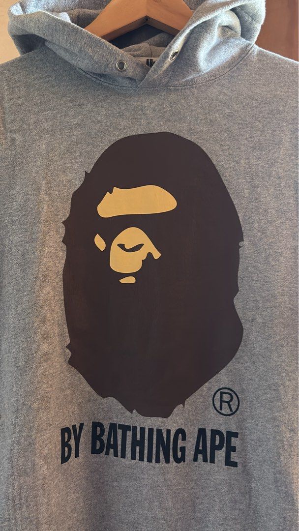 A Bathing Ape Grey Bape Head Hoodie (Category: Hoodies) located in Manila. Submitted by kobthrift.1223 (Listing ID 1467381100, Image 2). Description: - Authentic A Bathing Ape (Bape) grey hoodie - Classic brown Bape head logo and text print on chest - Cozy and warm fleece interior - Includes signature sleeve ape tag and neck tag - Features drawstring hood, front kangaroo pocket, and ribbed cuffs/hem.