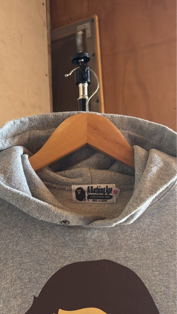 A Bathing Ape Grey Bape Head Hoodie (Category: Hoodies) located in Manila. Submitted by kobthrift.1223 (Listing ID 1467381100, Image 3). Description: - Authentic A Bathing Ape (Bape) grey hoodie - Classic brown Bape head logo and text print on chest - Cozy and warm fleece interior - Includes signature sleeve ape tag and neck tag - Features drawstring hood, front kangaroo pocket, and ribbed cuffs/hem.